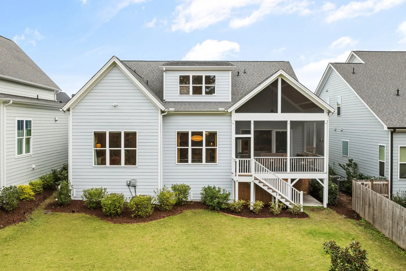 A clean two-story home exterior with a backyard